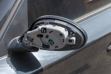 Hasarlı bir arabanın araba tarafındaki aynanın yakın görüntüsü. 