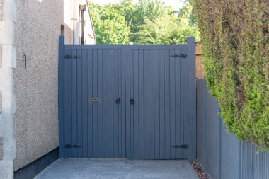 Ana caddedeki bir evin kurutma yoluna çıkan çift kapılı bir kapının yakın görüntüsü. 