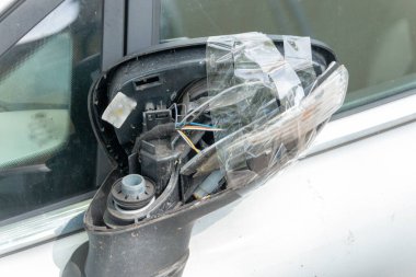 Bir araba-araç yan aynasının yakın görüntüsü birbirine bantlanmış ve sönmüş. 