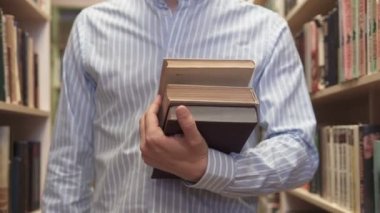 A man selects a book in the library
