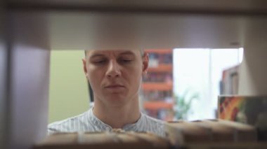 A man selects a book in the library