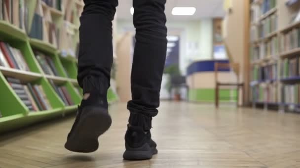 Man Går Genom Biblioteket Och Letar Efter Lämplig Bok — Stockvideo