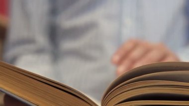Bir adam kitabı karıştırır, ilginç satırlar arar.