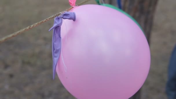 一个男孩刺破了一个充气气球 气球爆裂了 — 图库视频影像