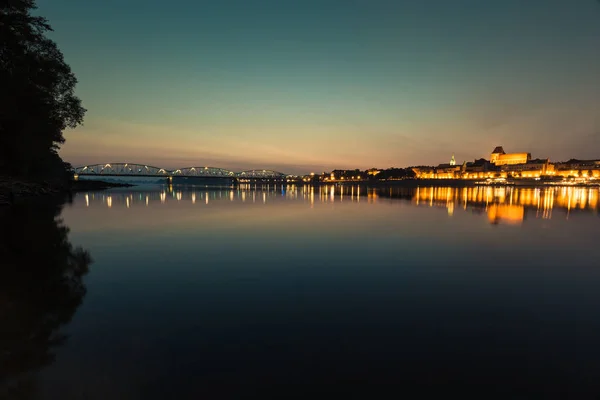 Staden av Torun i Polen, gamla stan skyline nattetid från Vistula — Stockfoto