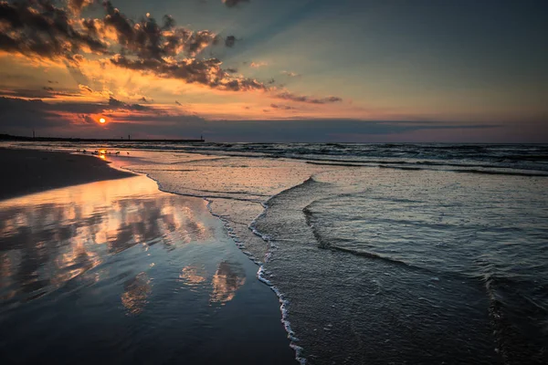 Pôr do sol na praia com um quebra-mar de madeira em Leba, Mar Báltico, Pó — Fotografia de Stock