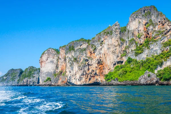 Cliff e o mar claro com um barco perto da ilha Phi Phi no sul — Fotografia de Stock