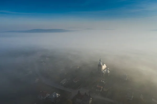 Surreal view of church almost completely hidden by fog — Stock Photo, Image