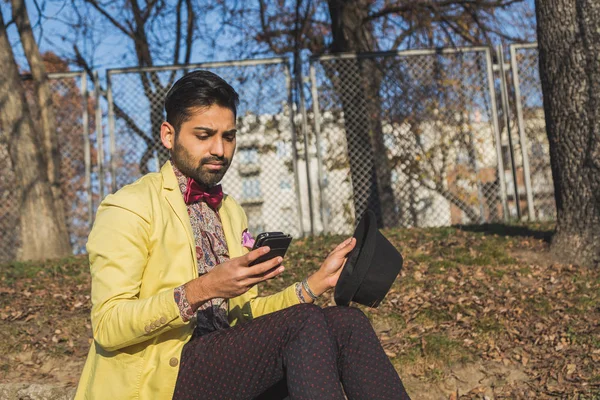Indiano bello uomo sms in un contesto urbano — Foto Stock