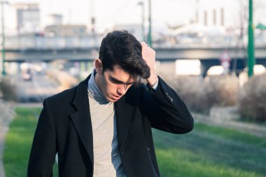 Güzel genç adam bir kentsel bağlamda poz