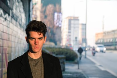 Güzel genç adam bir kentsel bağlamda poz