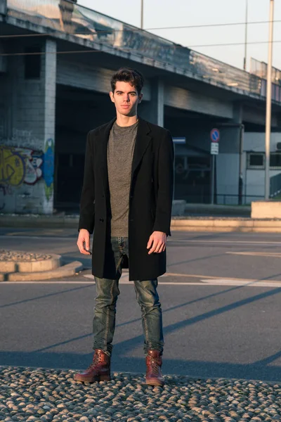 Hermoso joven posando en un contexto urbano — Foto de Stock