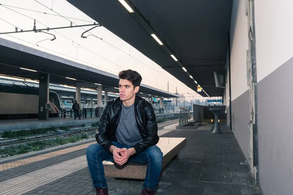 Beautiful young man posing in a train station — Stock Photo, Image