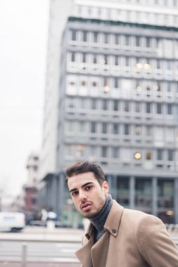 Güzel genç adam bir kentsel bağlamda poz