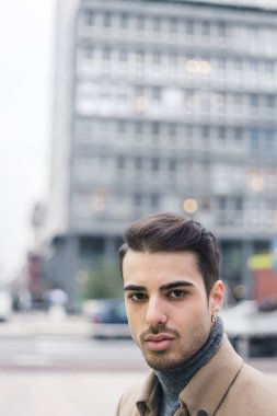 Güzel genç adam bir kentsel bağlamda poz