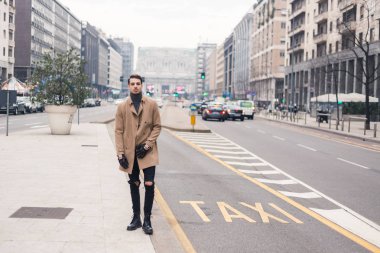 Güzel genç adam bir kentsel bağlamda poz