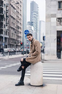 Güzel genç adam bir kentsel bağlamda poz