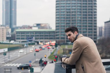 Güzel genç adam bir kentsel bağlamda poz