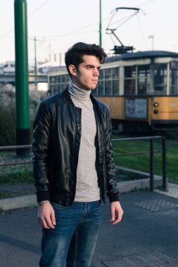 Güzel genç adam bir kentsel bağlamda poz