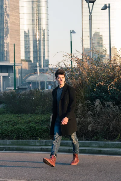 Hermoso joven posando en un contexto urbano — Foto de Stock