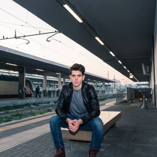 Beautiful young man posing in a train station — Stock Photo, Image