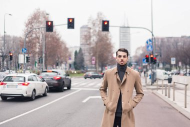 Güzel genç adam bir kentsel bağlamda poz