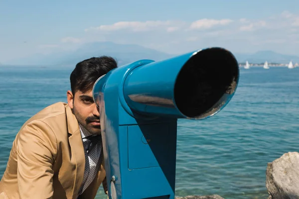 Όμορφος άνδρας κοιτάζοντας μέσα από ένα τηλεσκόπιο — Φωτογραφία Αρχείου