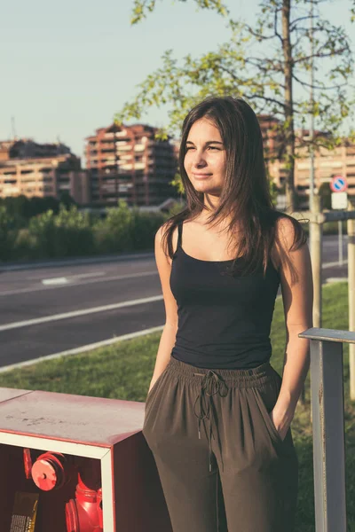 Jeune femme posant dans un contexte urbain — Photo
