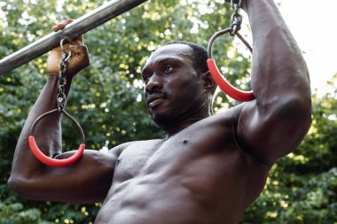 Atletik siyah adam bir şehir parkında poz