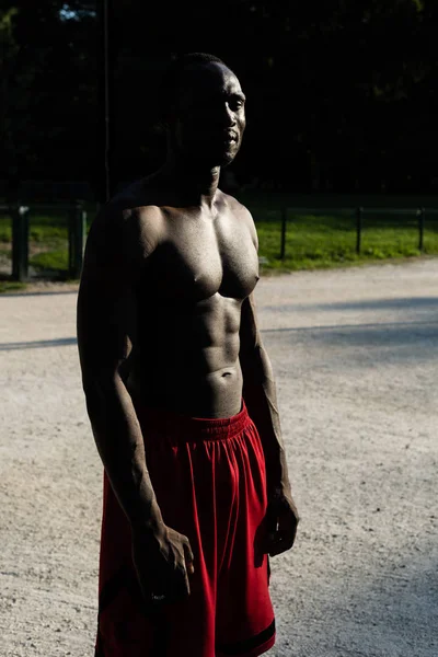 Urheilu musta mies poseeraa kaupungin puistossa — kuvapankkivalokuva