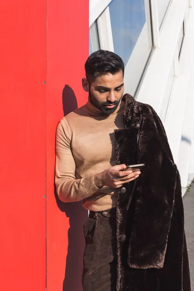 Junger indischer Mann textet im urbanen Kontext — Stockfoto