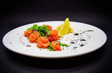 Siyah arka planda garnitürlü tuzlu somon.