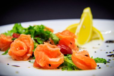 Siyah arka planda garnitürlü tuzlu somon.