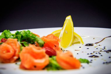 Siyah arka planda garnitürlü tuzlu somon.