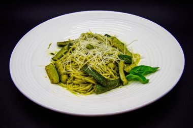 Siyah zemin üzerinde kabak ezmesi ve pesto sosu.