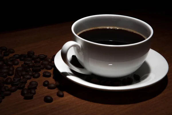 Kopp kaffe och bönor på bordet — Stockfoto