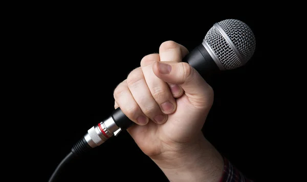 Man's hand holding a microphone — Stock Photo, Image