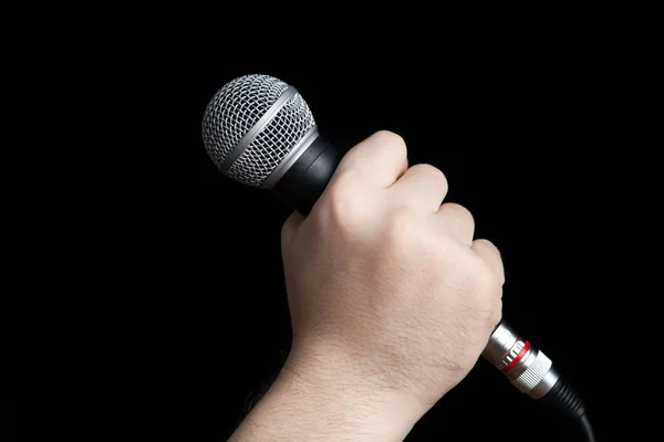 Man's hand holding a microphone — Stock Photo, Image