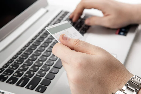 Mãos segurando um cartão de crédito e usando computador portátil — Fotografia de Stock