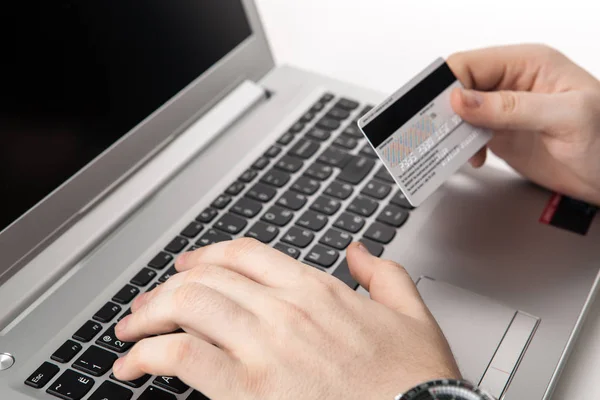 Hands holding a credit card and using laptop computer — Stock Photo, Image