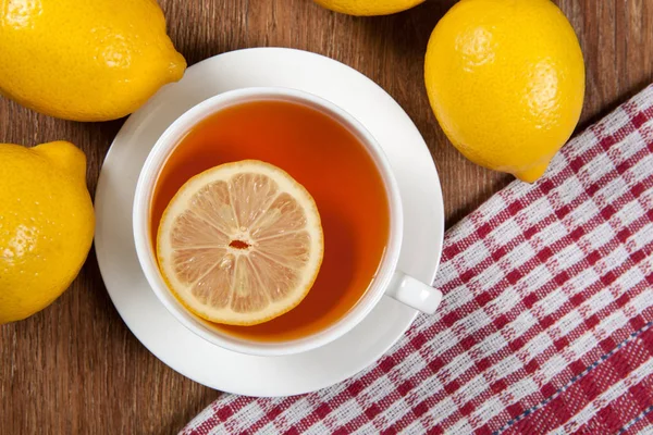 Bodegón de limones frescos en una mesa de madera con taza de té — Foto de Stock