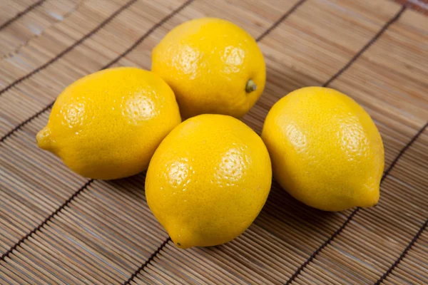 Still life of fresh lemons on a bamboo napkin — Stock Photo, Image