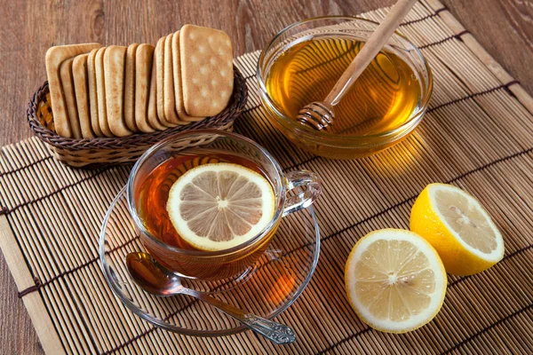 Натюрморт свежих лимонов на бамбуковой салфетке с чашкой чая — стоковое фото
