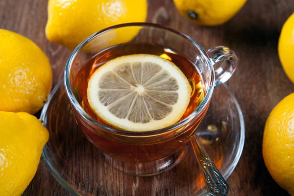 Bodegón de limones frescos en una mesa de madera con taza de té — Foto de Stock