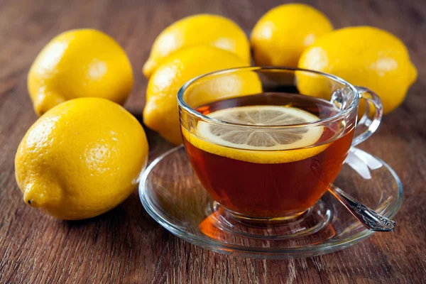 Bodegón de limones frescos en una mesa de madera con taza de té — Foto de Stock