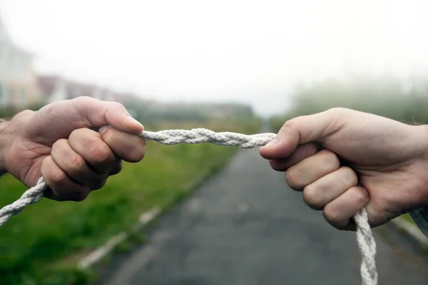 Two people pull the rope against each other — Stock Photo, Image