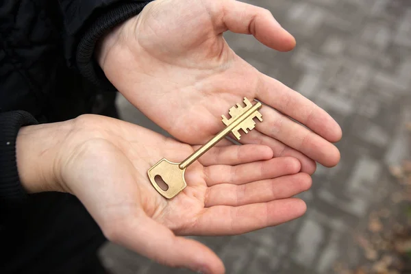 Mão detém a chave de um apartamento em um novo edifício — Fotografia de Stock