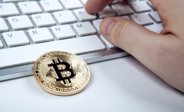 bir altın madeni para bitcoin ve insan el laptop klavye üzerinde