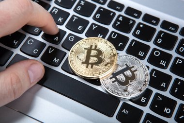 iki sikke bitcoin ve insan laptop klavye üzerinde el