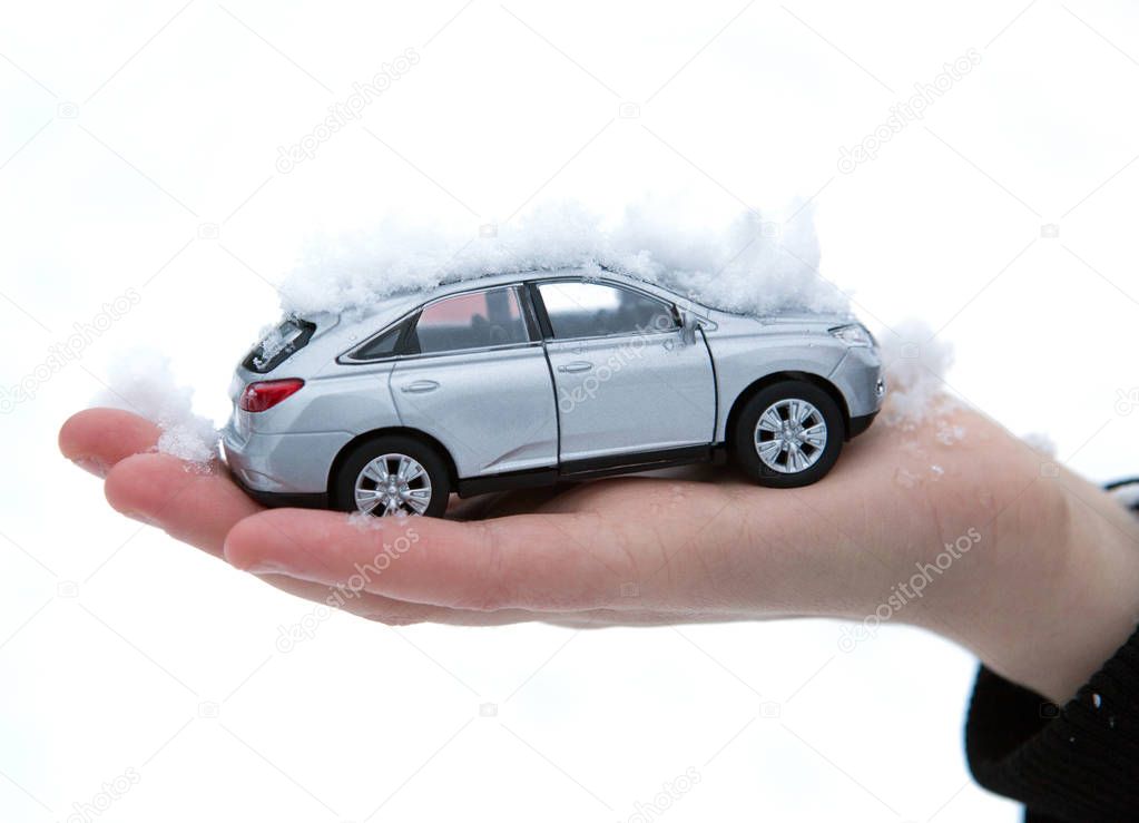 girl holds in her hand model of car with snow